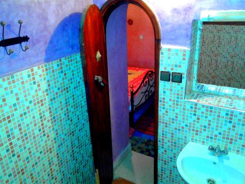 斯库拉Auberge Kasbah Tiriguioute的一间带水槽的浴室和一张位于客房内的床