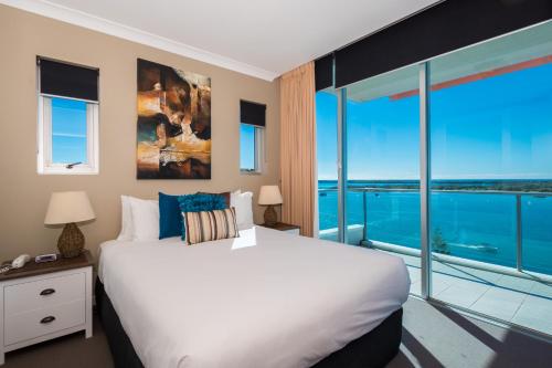 黄金海岸布罗德沃特银色海岸公寓酒店的卧室设有一张白色大床和大窗户