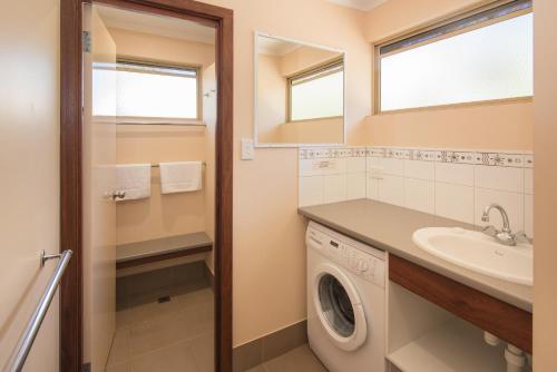 巴瑟尔顿Siesta Park Holiday Resort ABSOLUTE BEACHFRONT RESORT的洗衣房配有洗衣机和水槽