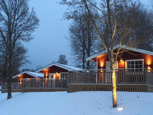 埃克舍Eksjö Camping & Konferens的雪中的房子,上面有灯