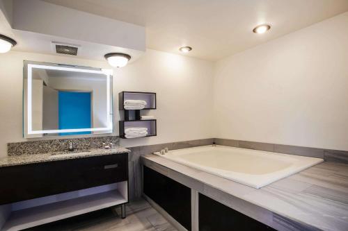 布莱克伍德布莱克伍德豪生快捷酒店的一间带大浴缸和水槽的浴室
