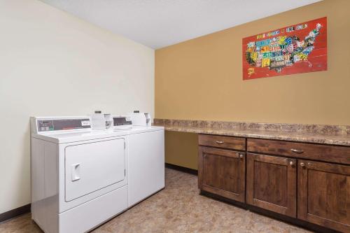 拉夫兰拉夫兰/柯林斯堡地区客之家酒店的洗衣房配有洗衣机和柜台。