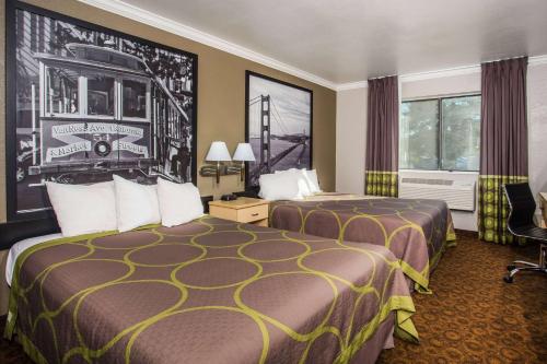 瓦卡维尔瓦卡维尔速8酒店的酒店客房设有两张床和窗户。