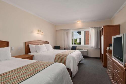 坎卢普斯坎卢普斯城市中心旅程住宿酒店的酒店客房设有两张床和一台平面电视。
