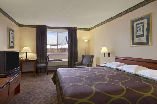 科罗拉多斯普林斯速8科罗拉多斯普林斯机场酒店的酒店客房,配有床和电视