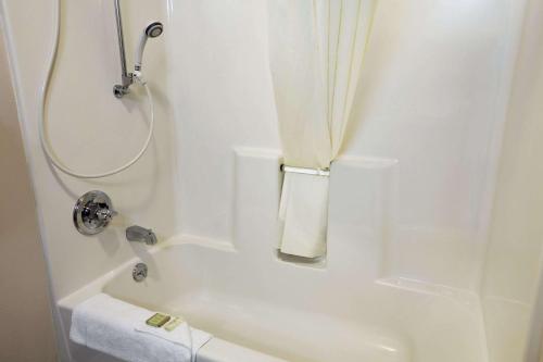 科罗拉多斯普林斯速8科罗拉多斯普林斯机场酒店的带淋浴和浴缸的白色浴室