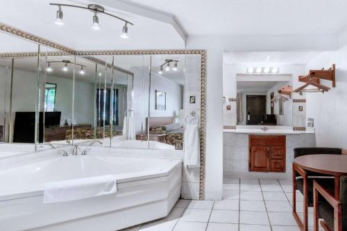 皮茨顿Knights Inn Pittston的白色的浴室设有浴缸和桌子。