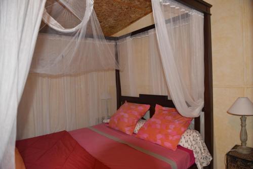 圣玛丽海伦娜别墅小木屋的一间卧室配有带窗帘和天篷的床