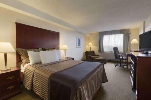 里士满Travelodge Hotel by Wyndham Vancouver Airport的酒店客房,配有床和电视