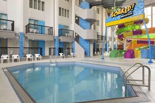 里贾纳The Atlas° Hotel的一个带水滑梯的酒店中庭的游泳池