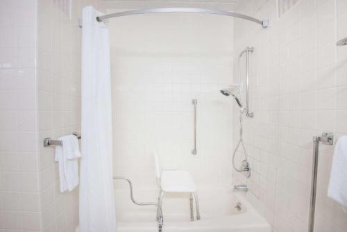 伊利速8伊利酒店的带淋浴和白色椅子的白色浴室
