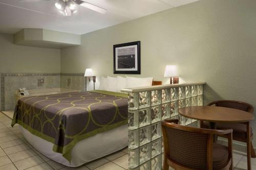 南帕诸岛南帕诸岛速8酒店的卧室配有一张床和一张桌子及椅子