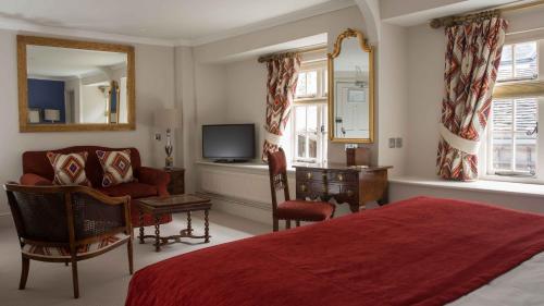 威尔汉姆普里奥里酒店的一间卧室配有一张床、一把椅子和电视
