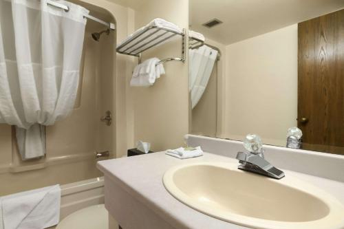 北湾北湾速8汽车旅馆的白色的浴室设有水槽和淋浴。