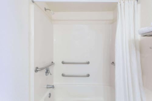 弗吉尼亚海滩弗吉尼亚海滩林恩海文骑士汽车旅馆的浴室配有淋浴帘和浴缸。