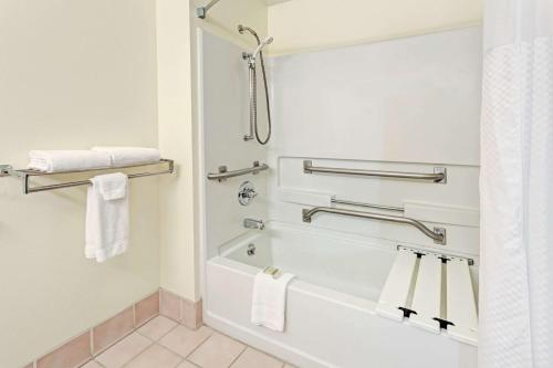 温莎温莎速8酒店的浴室配有浴缸、淋浴和毛巾。