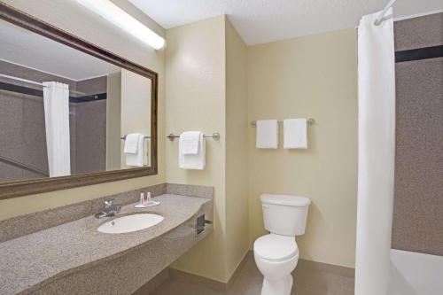 代托纳海滩代托纳比奇速8汽车旅馆的一间带卫生间、水槽和镜子的浴室