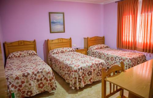 托梅略索桑丘旅馆的一间设有两张床和一张桌子的房间