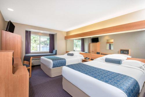 Hazelton温德姆哈泽尔顿/布鲁斯盾米尔麦克罗特套房酒店的酒店客房设有两张床和电视。