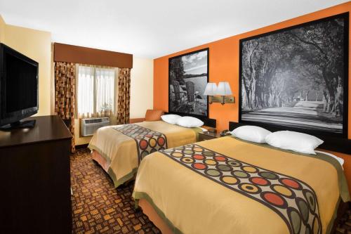 克莱夫Super 8 by Wyndham Clive IA的酒店客房设有两张床和一台平面电视。