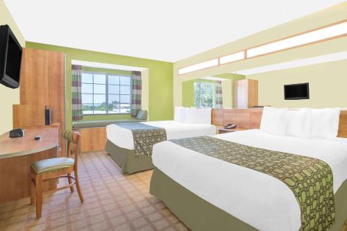 Tuscumbia塔斯坎比亚/马斯尔肖尔斯温德姆麦克罗特客栈&套房的酒店客房配有两张床和一张书桌