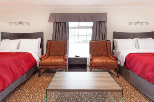 金斯顿金士​​顿骑士旅馆的酒店客房,配有两张床和两把椅子