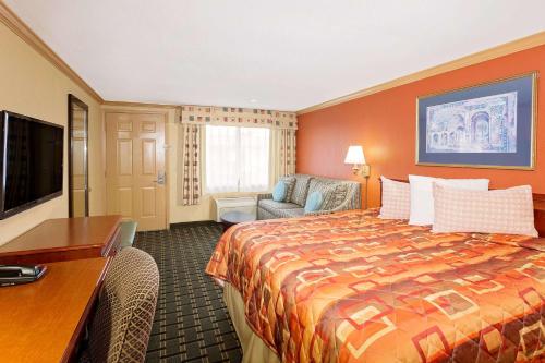 夏洛特港夏洛特港骑士酒店的配有一张床和一张书桌的酒店客房