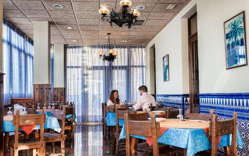 Alhama de Almería巴尔内亚里奥圣尼古拉斯酒店的两人坐在餐厅桌子旁