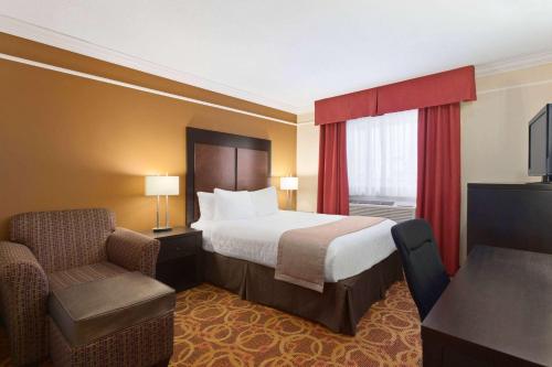 Meadow Lake梅多湖特拉维洛基酒店的配有一张床和一把椅子的酒店客房
