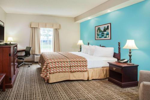 杰克逊Howard Johnson by Wyndham Jackson的酒店客房设有一张大床和一台电视。
