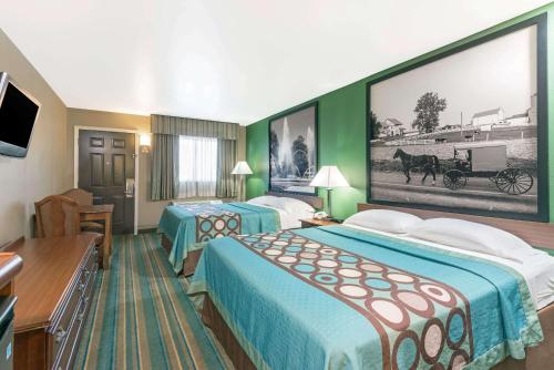 GreencastleSuper 8 by Wyndham Greencastle的酒店客房设有两张床,墙上挂着一张大照片。
