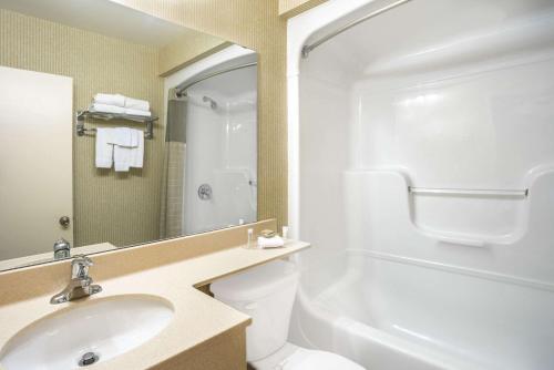 金斯顿金斯顿速8汽车旅馆的一间带水槽、卫生间和镜子的浴室