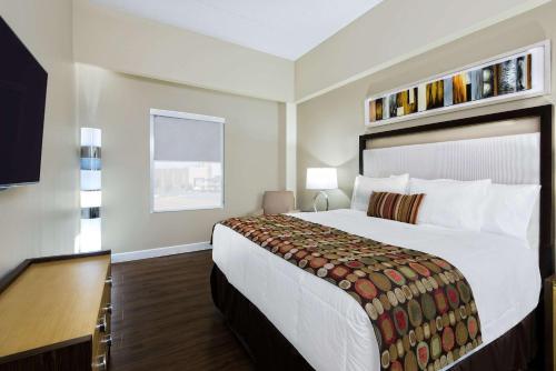 麦卡伦Hawthorn Suites by Wyndham McAllen的酒店客房设有一张大床和一张书桌。