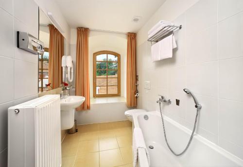 捷克克鲁姆洛夫麦林酒店的带浴缸、盥洗盆和卫生间的浴室