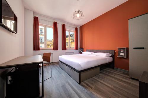 罗马罗马你好的一间卧室设有橙色的墙壁、一张床和一张书桌