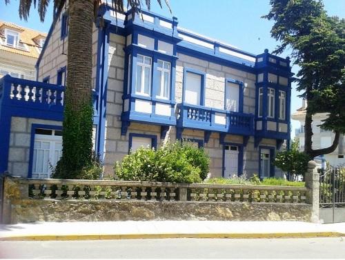 艾利亚德亚罗萨Casa Illa de Arousa, Galifornia!!的蓝色和白色的房子,前面有栅栏