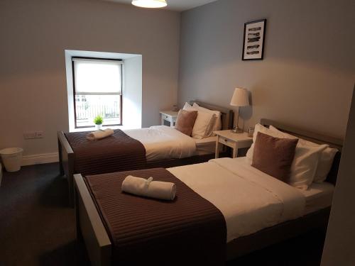 恩尼斯凯里The Enniskerry Inn的酒店客房设有两张床和窗户。