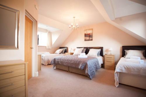 布里真德Ballas Farm Country Guest House的阁楼卧室配有两张床和吊灯。