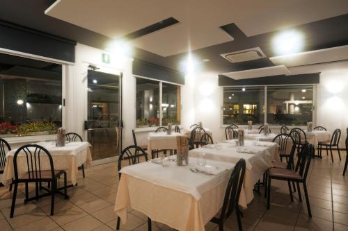 阿拉西奥Albergo Anita Alassio的餐厅设有白色的桌椅和窗户。