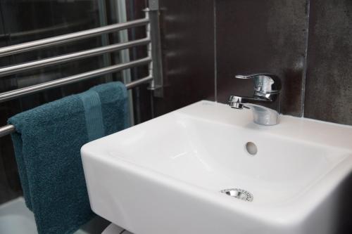 蒂米什瓦拉Ultracentral, brand new, modern and cozy apartment的浴室设有白色水槽和蓝色毛巾。