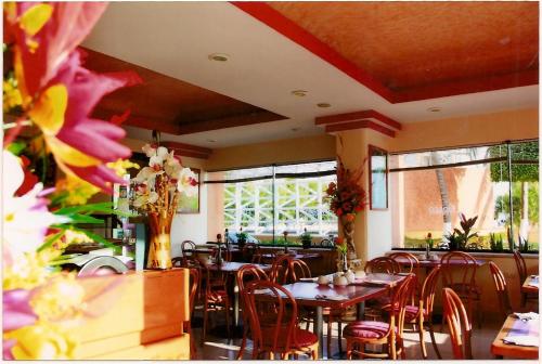 卡门城Hotel del Parque的用餐室设有桌椅和窗户。