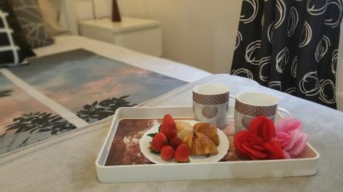 略夫雷加特河畔奥斯皮塔莱特Apartment Fira Bcn Camp Nou的桌上的草莓和羊角面包等食物托盘