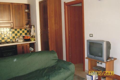 西尼斯科拉Villetta Mirto的客厅配有绿色沙发和电视