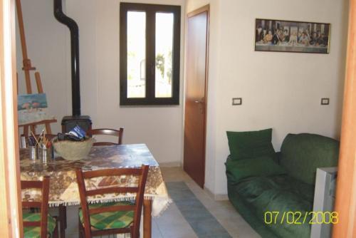 西尼斯科拉Villetta Mirto的客厅配有绿色沙发和桌子