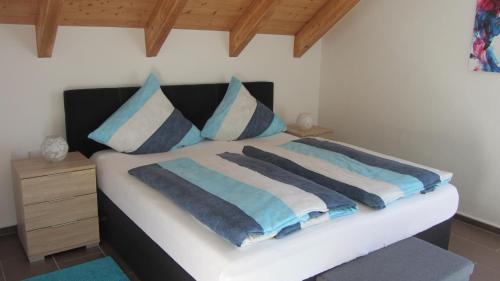 NeuenbauFerienwohnung Am Alten Forsthaus Neuenbau的一间卧室配有一张带蓝色和白色枕头的床