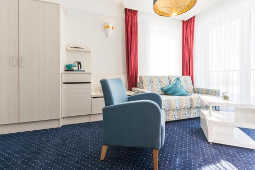 奥斯特巴德里克赫菲德尔加尼酒店的客厅配有蓝色椅子和沙发