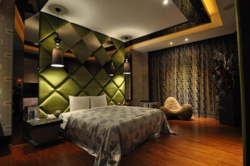 Ho-mei七星精品汽车旅馆的一间卧室配有一张带绿色墙壁的床