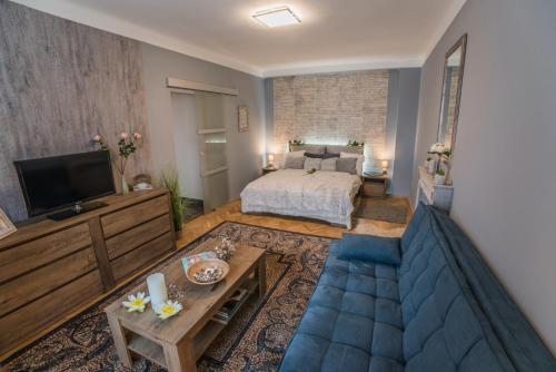 布达佩斯河畔珍宝公寓的客厅配有床和蓝色沙发