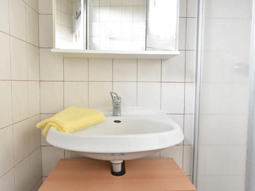 博尔滕哈根Gorgeous home with swimming pool and Jacuzzi Sea view !的浴室设有白色水槽和黄色毛巾。
