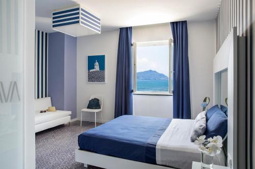 蒙泰迪普罗奇达Villa Aragonese Rooms的一间卧室设有蓝色的床和窗户。